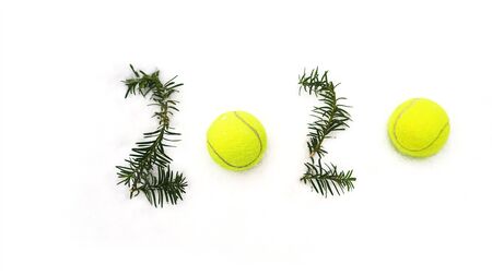 Tennis Christmas and 2020 New Year concept with tennis balls and fir branches with numbers on white...