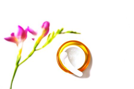Beauty skin care cosmetic cream serum, gel or mask as cosmetics product with tropical flowers on white background, isolated. Flat lay top view copy space. Beauty minimal concept. Selective focus.の写真素材