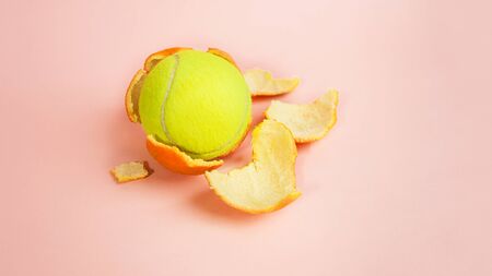 Tennis ball in an orange, concept on trendy pink coralの写真素材