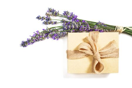 Beauty setting with lavender flowers and gift box natural color with bow on white background, isolated. Close-up. Copy space. Flat lay, top view. Beauty, medical clinic, spa concept.の写真素材