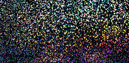 Blurred bokeh light colorful holographic background, Christmas and New Year holidays dark background. Party concept. Festive holiday bright backdrop. Defocused.の写真素材