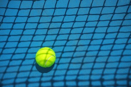 Summer sport concept with tennis ball and net on hard tennis court. Flat lay, top view, copy space.の写真素材