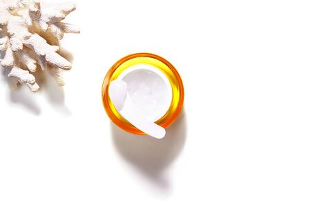Skin care cosmetic cream, serum, gel or mask as cosmetics product with tropical coral on white background, isolated. Flat lay, top view, copy space. Beauty concept. Minimal modern.の写真素材