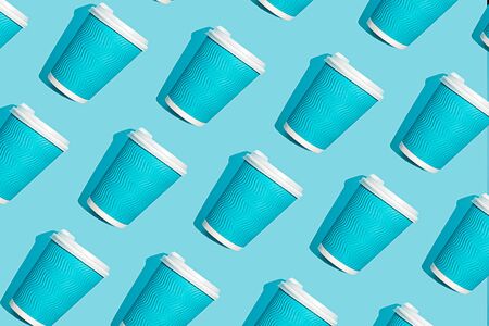 Coffee pattern of blue paper cup for coffee on bright blue background. Pop art minimal flat lay style design, creative concept. Top view. Copy space. Banner.の写真素材