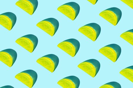 Creative pattern of yellow citrus lemon slices as ice for cocktail on pastel blue background. Pop art minimal flat lay style design, summer drink cold creative concept. Top view, flatlay. Copy space.の写真素材