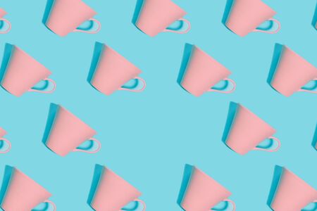 Coffee pattern of pink coral cup for coffee on bright blue background. Pop art minimal flat lay style design, creative concept. Top view. Copy space. Banner.の写真素材