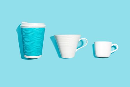 Coffee pattern of white ceramic and blue paper cup for coffee on bright blue background. Pop art minimal flat lay style design, creative concept of diversity. Top view. Copy space. Banner.の写真素材