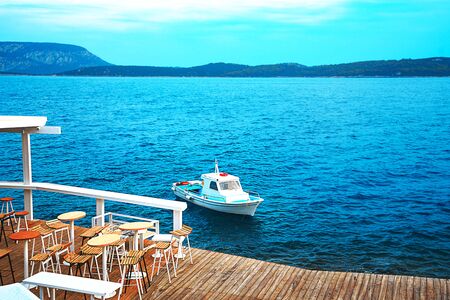 Traditional fishing boat in turquoise water of the Aegean Sea on the coast of the port town Ermioni,...