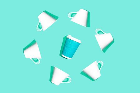 Trendy coffee pattern is made from blue paper cup for coffee and white ceramic cups on bright mintの写真素材