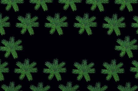 Christmas frame made of natural green fir tree branches as snowflakes on blackの写真素材
