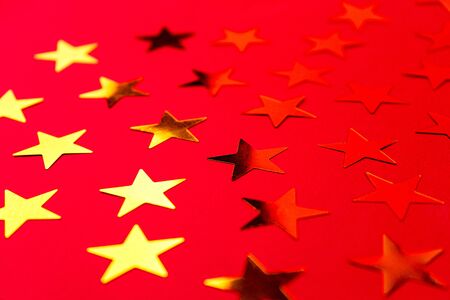 Bunch of gold stars on red pink background. Festive concept. Christmas, New Year, Birthday party...