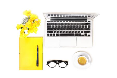 Workspace with laptop computer, fashion glasses, cup of coffee and yellow flower, notebook with pen on white background, isolated. Top view. Flat lay. Concept online shopping.の写真素材