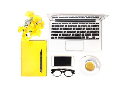 Workspace with laptop computer notebook, fashion glasses, cup of coffee, mobile phone, and yellow flower, notebook with pen on white background, isolated. Top view. Flat lay. Concept online shopping.の写真素材