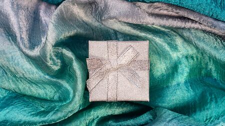 Silk cloth in trendy green mint blue colors and silver gift box as texture holidayの写真素材