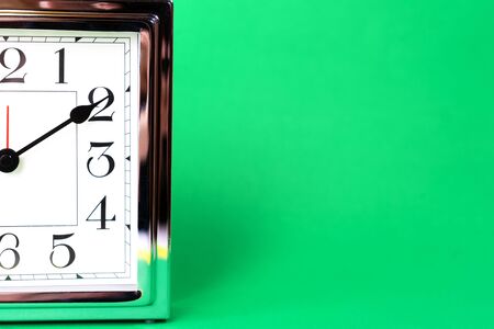 Holiday time, Black Green Friday concept with metal silver clock on green color background....