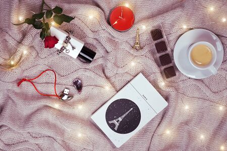Romantic background with coziness concept flat lay: plaid, cup of coffee, notebook, red rose, chocolate, candles and bracelet, flash drive. Valentines day card concept. March 08 Womens Day.の写真素材