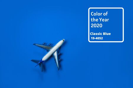 Blue color of the Year 2020 inscription. Model airplane, plane on blue background. Directly above. Travel, vacation, summer concept. Flat lay, top view, cope space.の写真素材