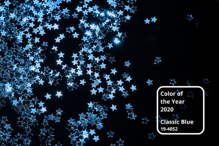 Classic Blue color 2020 concept. Splash of shining silver stars on a black background.