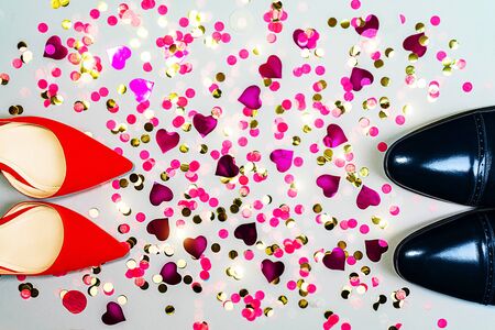 Valentines day concept with man and woman shoes and colorful confetti.の写真素材