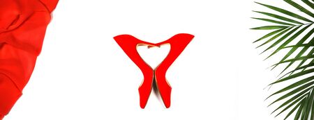 Top view party outfit: red shoes, ropical monstera leaves on white background, isolated. Party Valentine's Day Christmas New Year wedding dinner layout. Flat lay.の写真素材