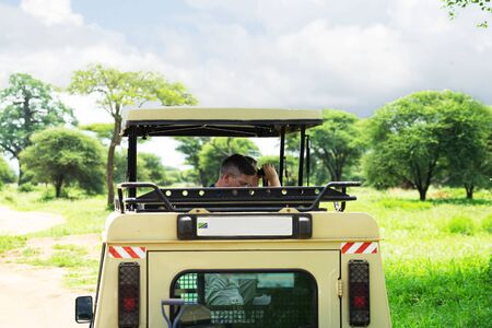 Tanzania, Serengeti national park - January 03, 2020: Tourists from utility vehicle jeep, photographed wild animals in wildlife on jeep safari.のeditorial素材