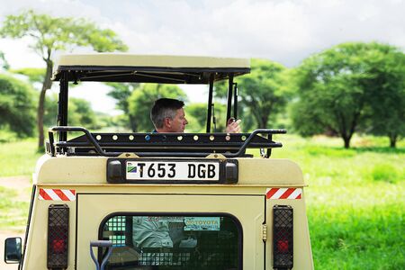 Tanzania, Serengeti national park - January 03, 2020: Tourists from utility vehicle jeep, photographed wild animals in wildlife on jeep safari.のeditorial素材
