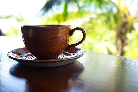 Cup of coffee on tropical background. Tropical travel concept. Close up.の写真素材