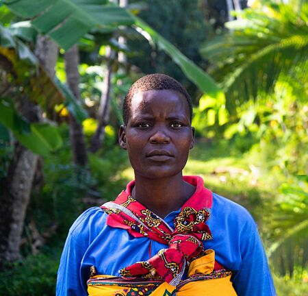 Tanzania, Zanzibar - January 22, 2020: African woman in a bright dress on tropical nature...