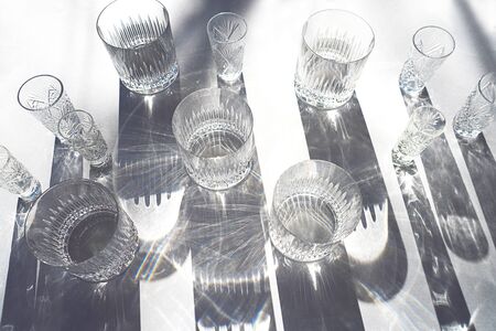 Trendy pattern made with glasses and shadows on gray white background. Sunlight through glass of water.の写真素材