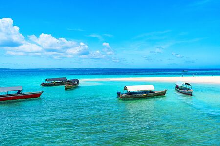 Panoramic view of a beautiful sunny day on sandy beach and fishing boats in the Zanzibar. Tropical travel concept.の写真素材