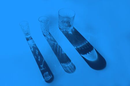 Trendy color pattern made with glasses and shadows on classic blue background. Classic Blue color of the Year 2020 inscription.の写真素材