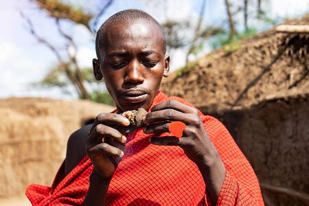 SERENGETI, TANZANIA - January 7: African man holding a smoldering cake in his hands with a red heart ring. Tanzania, Africa.のeditorial素材