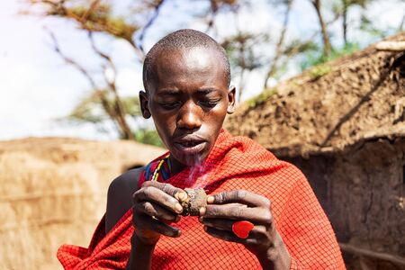 SERENGETI, TANZANIA - January 7: African man holding a smoldering cake in his hands with a red heart ring. Tanzania, Africa.のeditorial素材