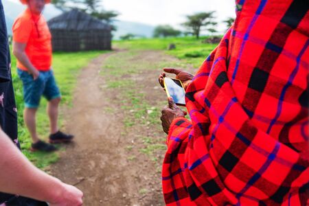 African man in traditional dress holding a cellphone. Tanzania, Africa. Close up.の写真素材