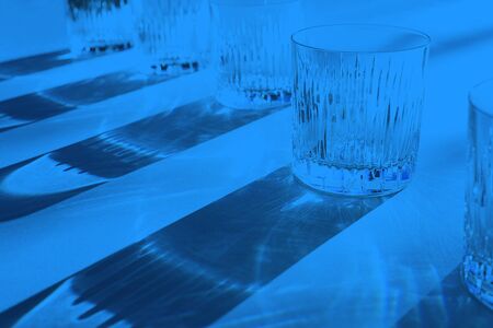 Trendy color pattern made with glasses and shadows on classic blue background. Classic Blue color of the Year 2020 inscription.の写真素材