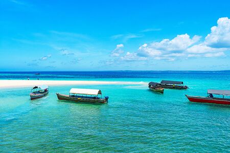 Panoramic view of a beautiful sunny day on sandy beach and fishing boats in the Zanzibar. Tropical travel concept.の写真素材