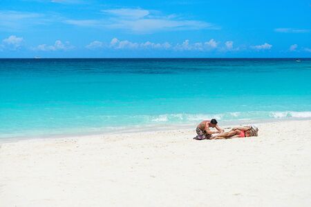 Tourist taking photo at the sea on tropical vacation. Couple of traveler enjoying on the beach.の写真素材
