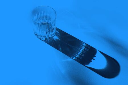 Trendy color pattern made with glasses and shadows on classic blue background. Classic Blue color of the Year 2020 inscription.の写真素材