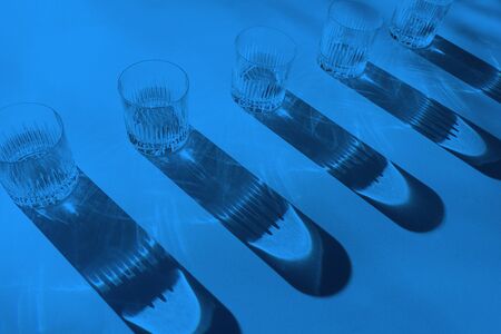 Trendy color pattern made with glasses and shadows on classic blue background. Classic Blue color of the Year 2020 inscription.の写真素材