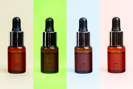 Multi color herbal oil bottles aroma dropper on glass. Essential natural oils for face and body. Organic minimalis layout.の写真素材