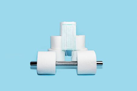 Concept of toilet paper and dumbbell for home quarantine from coronavirusの写真素材