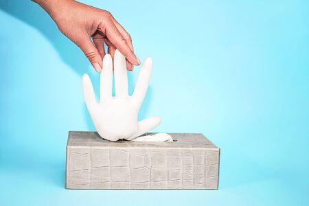 Concept of prevention from virus with rubber latex gloves on blue