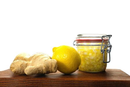 Ginger, lemon are ingredients of ginger water or tea prevents coronavirus on wooden board, isolated. Alternative medicine. Traditional Indonesian, Asian drinks.の写真素材