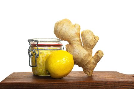 Ginger, lemon are ingredients of ginger water or tea prevents coronavirus on wooden board, isolated. Alternative medicine. Traditional Indonesian, Asian drinks.の写真素材
