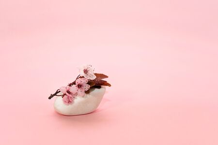 Spring cherry flower on top white stone on a pink background. Flat lay, copy space. Cherry blossom.の写真素材