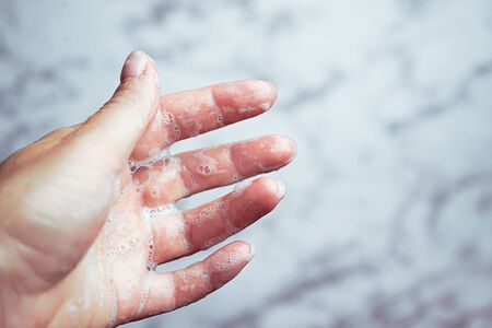 Washing hands woman on marble background, Coronavirus prevention hand hygiene. Coronavirus pandemic protection by cleaning hands. Outbreak of coronavirus concept. Novel virus - COVID-19, 2019-nCoV.の写真素材