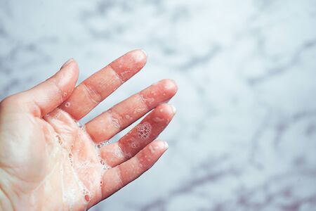 Washing hands woman on marble background, Coronavirus prevention hand hygiene. Coronavirus pandemic protection by cleaning hands. Outbreak of coronavirus concept. Novel virus - COVID-19, 2019-nCoV.の写真素材