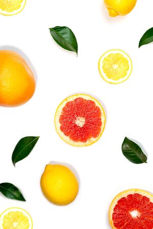 Creative layout made of lemon, grapefruit and green leaves on white background. Flat lay, close up. Tropical food summer concept.の写真素材