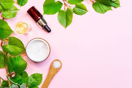 Skin care products, natural cosmetic. Flat lay image on pink background. Natural cosmetic skincare bottle, serum and organic green leaf. Homemade and beauty product concept.の写真素材