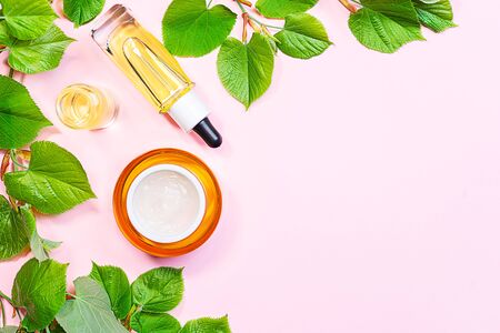 Skin care products, natural cosmetic. Flat lay image on pink background. Natural cosmetic skincare bottle, serum and organic green leaf. Homemade and beauty product concept.の写真素材